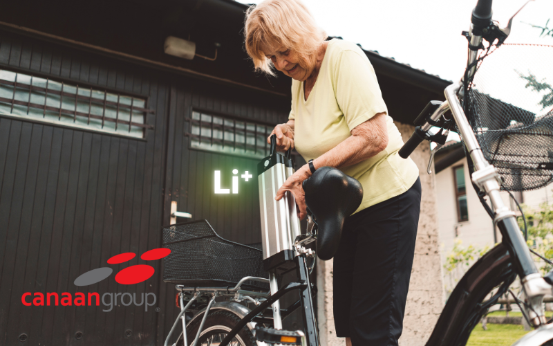 A woman holding an electric bicycle containing a lithium ion battery. This is a cover photo for an article about importing e-bikes containing lithium ion batteries as dangerous goods in Canada.